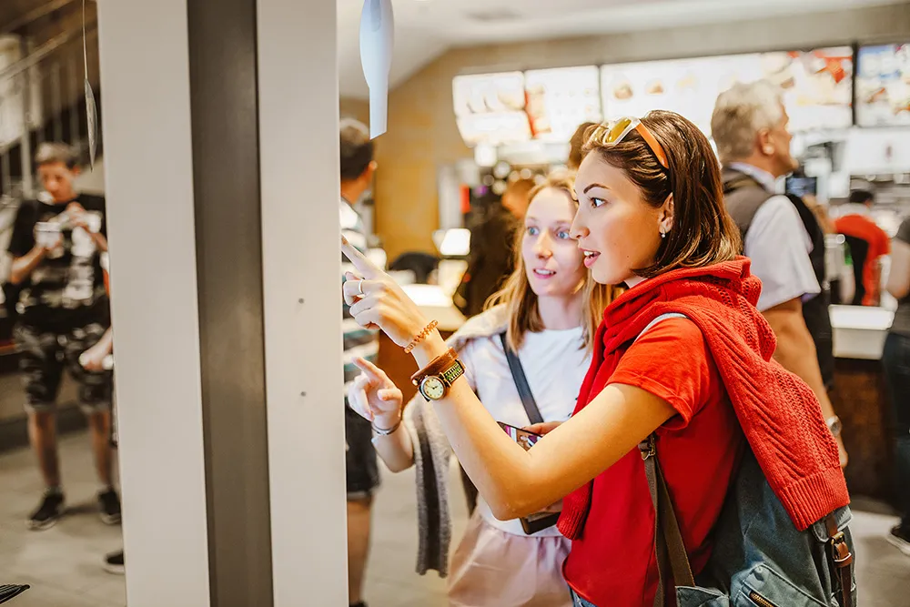 Two women order from a kiosk  marsfoodservices image
